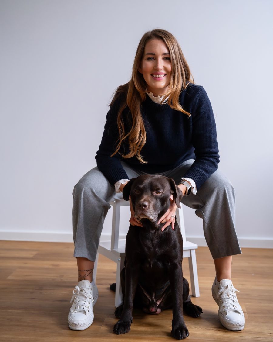 Fabienne Lange lachend mit ihrem braunen Labrador
