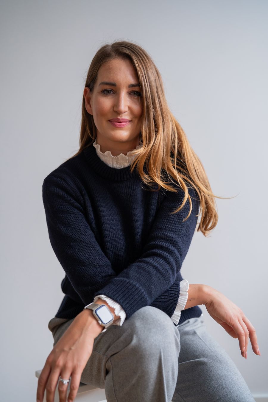Fabienne Lange im dunkelblauen Pullover, auf einem Hocker sitzend